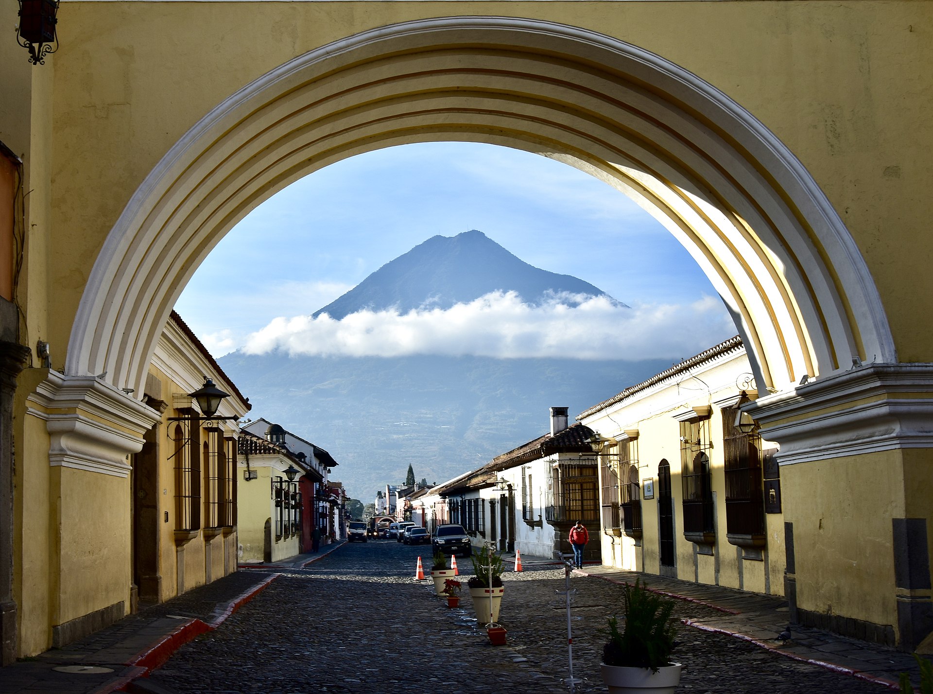 A cobblestone street in Antigua Guatemala with Volcán de Agua in the distance