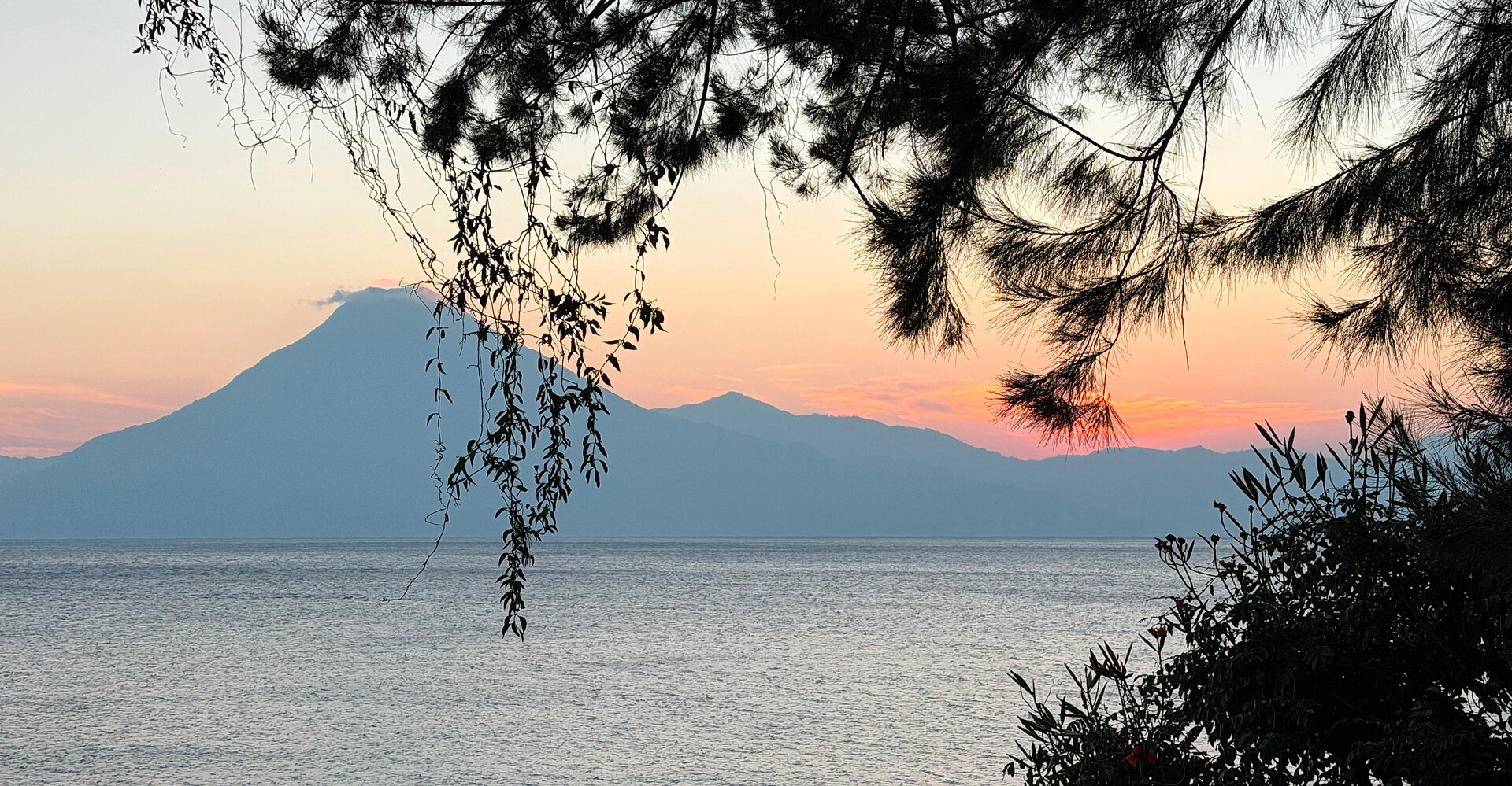 Lake Atitlán at sunset with volcanoes in silhouette